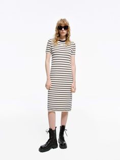 MO&Co. Women's Round Neck Striped Dress Crafted with a blend of wool and fabric, this mid-length T-shirt dress boasts a modern silhouette and stylish striped design. Perfectly pair with short boots for a minimalist, fashion-forward look. Features : - Midi T-shirt dress silhouette- Classic black and white stripes- Round neck, short sleeves Code: MBD1DRS038The back length of size S is 104cmMATERIALS & CARE Material: 67.7% Wool 32.3% PolyesterWrap metal parts before dry cleaning.REMINDER: All items