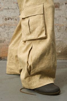 The Multi-Pocket Deconstructed Cargo Pants are a harmonious blend of laid-back style and practicality. Designed to serve the needs of the modern urbanite, these pants feature an array of pockets: flap-covered ones on the seat and right leg for security, and open pockets on the left and just below the waistband for easy access. This variety in pocket design is not only functional but also adds to the deconstructed aesthetic, offering depth and a multi-layered appearance. They are crafted from pre Big Pockets Fashion, Clothing Material Fabrics, Loosely Fitted Cargo Jeans With Tapered Leg, Beige Utility Pants With Patch Pockets, Fall Beige Cargo Jeans With Side Pockets, Urban Parachute Pants With Multiple Pockets And Tapered Leg, Urban Parachute Pants With Tapered Leg And Multiple Pockets, Utility Cotton Pants With Pockets, Khaki Workwear Bottoms With Pockets