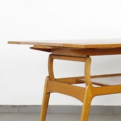 a wooden table sitting on top of a tiled floor