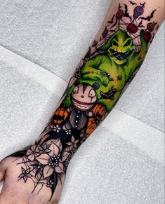 a person's hand with a tattoo on it that has an image of a green creature