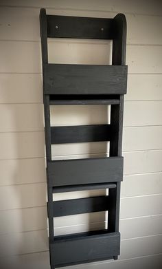 a shelf made out of pallets in the corner of a room with white walls