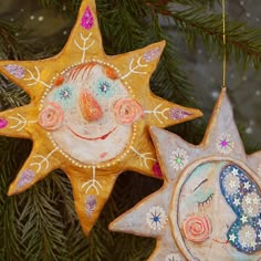 two ceramic ornaments hanging from a christmas tree