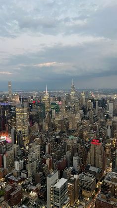 an aerial view of the city at night with lights and skyscrapers in the foreground