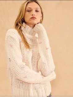 Mock Neck Long Sleeves Crocheted Stitched Pink Polka Dots Hip Length Slim Fit Add this adorable & cozy sweater to your fall & winter wardrobe today! Features a mock neck, long sleeves & unique stitched pink polka dots that adds a charming feminine touch to the sweater. Whether you are going to a casual dinner or lounging on the weekend, this piece will keep you warm & stylish. Pair with light wash denim, pearls & flats for a casual date night look! 📦 Free standard shipping on orders $150 or mor Spring High Neck Knitted Sweater, Cozy Turtleneck Sweater For Spring, Spring Textured Knit Sweater With Funnel Neck, Winter Funnel Neck Pink Sweater, Pink Funnel Neck Sweater For Winter, Cozy Spring Turtleneck, White Textured Knit Turtleneck For Winter, Spring Cozy Funnel Neck Sweater, Cozy Funnel Neck Spring Sweater