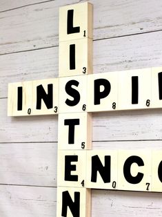 a cross made out of scrabble tiles with the words inspire written on it