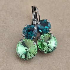 ♡ Genuine Austrian Crystal  ♡ Two stone earrings ♡ 12mm Rivolis (0.472") ♡ Color: Peridot ♡ 8mm Chatons (0.315") ♡ Color: Emerald ♡ Antique Silver plated (nickel free)  ♡ Lever backs ♡ 1.25" long, .472" wide ♡ Matching bracelet listed separately ♡ Handcrafted with love and attention to detail Nickel Free Round Green Earrings, Nickel-free Green Round Earrings, Green Nickel-free Round Earrings, Green Round Earrings, Handmade Green Crystal Earrings, Stone Drop Earrings, Earrings Antique, Matching Bracelet, Matching Bracelets