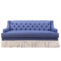 a blue couch sitting on top of a wooden table next to a white floor rug