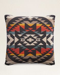 a black and orange pillow on a white background with an abstract design in the middle