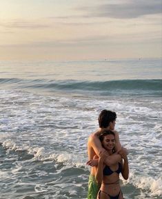 two people in the ocean hugging each other