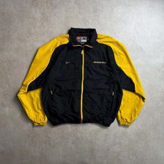 Size: M Fits like a: M Condition: Excellent * Vintage 90's Nike Mizzou jacket with iconic design and sporty flair. Measurements (cm): Chest: 64 cm Length: 71 cm Shoulders: 56 cm Arms: 64 cm *Please note that all garments are vintage or second-hand and show signs of wear. We carefully examine the condition of the garment to price our products. Returns or exchanges are not accepted, all sales are final. #NikeJacket #VintageNike #RetroStyle #SportsFashion #90sFashion Casual Fall Windbreaker For Sports Events, Casual Track Jacket For Fall Sports Events, Casual Fall Track Jacket For Sports Events, Casual Crew Neck Outerwear For Sports Events, Sporty Varsity Jacket For Sports, Sporty Varsity Jacket With Pockets For Sports, Urban Long Sleeve Windbreaker For Sports Season, Casual Crew Neck Sports Outerwear, Urban Style Long Sleeve Windbreaker For Sports