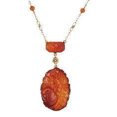 Finely detailed vintage Art Deco era carved carnelian necklace (circa 1920s to 1930s), crafted in 14 karat yellow gold.    The larger carnelian drop measures 1 1/2 x 1 inch, with the smaller rectangular piece measuring 15mm x 9mm. Small 4.5mm beads are set into the chain. The carnelian is in very good condition and free of cracks or chips.    Carnelian is carved in a floral and botanical motif, set into a beautiful ornate infinity link chain. The necklace is great worn as a statement piece or layered with your fine jewelry from any era.    The necklace is in very good original condition and was lightly cleaned and polished.    Particulars:    Weight: 14 grams    Stones: The larger carnelian drop measures 1 1/2 x 1 inch, with the smaller rectangular piece measuring 15mm x 9mm. Small 4.5mm b Formal Orange Carnelian Necklace, Vintage Carved Orange Jewelry, Vintage Orange Carved Jewelry, Orange Carved Vintage Jewelry, Antique Carved Yellow Gold Necklaces, Formal Carnelian Cameo Jewelry, Formal Cameo Jewelry In Carnelian, Formal Cameo Carnelian Jewelry, Elegant Carved Orange Jewelry