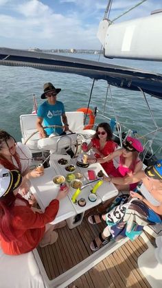 people sitting at a table on a boat in the ocean eating and drinking drinks from bowls