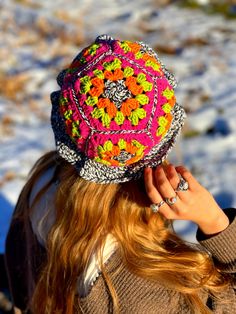 a woman wearing a colorful hat in the snow