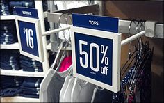 a sign that says 50 % off hanging on a rack