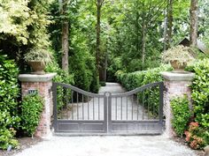 an iron gate in the middle of a garden