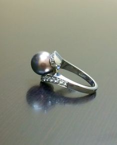 DeKara Designs Collection Beautiful Art Deco/Vintage/Modern Style Pearl Engagement Ring. Metal- 18K White Gold, .750. Stones- 10 MM Round Tahitian/South Sea Black Pearl, 24 Round Diamonds, F-G color VS1 clarity, 0.62 Carats. The ring is beautiful with a unique Tahitian pearl that is round in shape. This pearl changes from champagne brown, to a purple bronze color. This is a fantastic pearl that is also rare to find. The diamond has two rows of pave set diamonds that are graduating from big to sm High Luster Round Cut Rings For Formal Occasions, Formal Round Cut High Luster Rings, Formal High Luster Round Cut Rings, Elegant Formal Rings With High Luster, Elegant High Luster Rings For Formal Occasions, High Luster Diamond Wedding Rings, White Gold High Luster Rings For Anniversary, Silver Pearl Ring With Polished Finish For Wedding, Black Luxury Pearl Ring For Formal Occasions