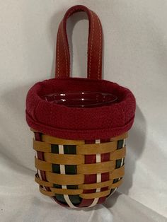 a red basket with brown handles on a white background