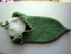 a crocheted green and white bag sitting on top of a table