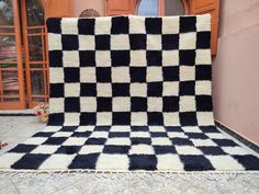 a black and white checkered rug sitting in front of a door