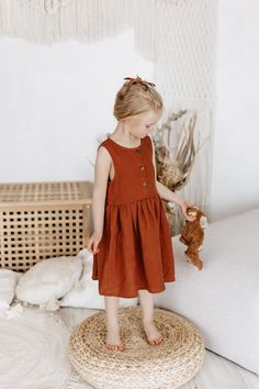 This lovely linen dress with buttons is suitable for a wide range of age - from baby girls of 6 months to early teen age of 12. Design of this A-line summer dress is ageless and will suit birthday or any other formal event like wedding, baptism, or else.  This dress has cute wooden buttons and perfect knee length. Buttons let it very easy to put this dress on over the shoulders. Linen dress has wide skirt and your little girl will love spinning around with it like a little butterfly. This dress Cute Linen Beach Dress, Brown Button Closure Dress For Beach, Brown Button Closure Beach Dress, Brown Beach Dress With Button Closure, Cotton Sleeveless Buttoned Dress For The Beach, Sleeveless Cotton Dress With Buttons For The Beach, Cotton Sleeveless Beach Dress With Button Closure, Beach Sleeveless Cotton Dress With Buttons, Brown Beach Dresses With Buttons