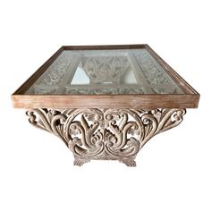 a glass and wood table with an intricate design on the top, against a white background