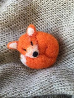 an orange stuffed animal laying on top of a blanket