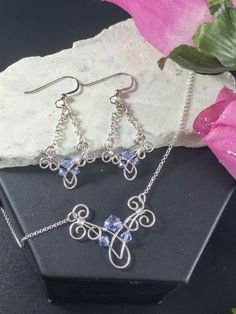 These earrings are whimsical and elegant. Each is handcrafted with sterling silver wire with Swarovski Crystals. The swirls and loops add a touch of texture to these gorgeous earrings. They dangle approximately 2 inches from French Hook ear wires with silver beads. A matching pendant with the same design is also sold in this shop. (Sold separately) It measures 1 1/4 wide and 1 inch tall and comes with an 18 inch sterling silver chain. https://www.etsy.com/listing/778727394/elegant-sterling-silve Literal Legend, Anniversary Gifts For Her, Wire Craft, Wire Jewelery, Easy Jewelry, Bridal Jewelry Set, Diy Bracelet Designs, Silver Earrings Handmade, Wardrobe Ideas