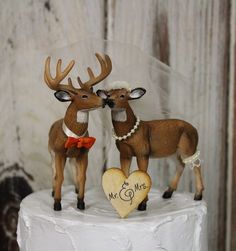 two deer figurines on top of a wedding cake