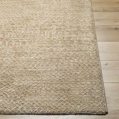 a beige rug on the floor with wooden floors