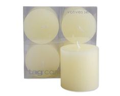 two white candles sitting next to each other in front of a box with the tag candle logo on it