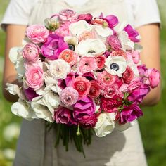 a woman holding a bouquet of pink and white flowers