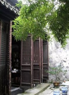 an outdoor area with potted plants and wooden doors