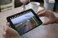 a person is holding up a camera to take a photo on a tablet computer screen