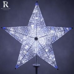 a white lighted star on a black pole