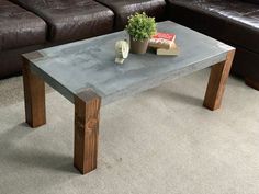 a table with a potted plant on it in front of a brown leather couch