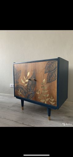 a wooden cabinet with leaves painted on it