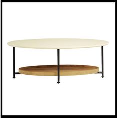 a table with a wooden tray underneath it and a black frame around the top that holds a white coffee table