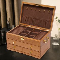 an open wooden jewelry box sitting on top of a table