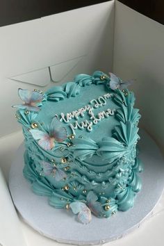 a blue birthday cake with butterflies on it