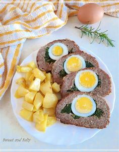 meatloaf with boiled eggs and pineapple on a plate next to an egg