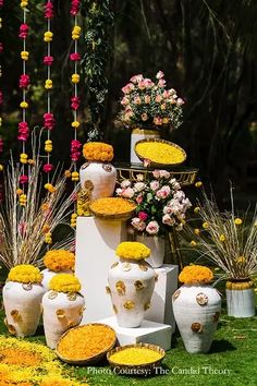 an arrangement of vases and flowers on display in the grass at a wedding ceremony