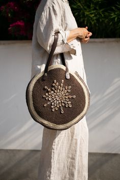 Handcrafted with meticulous care, this exceptional bag is a true gem for women who appreciate unique accessories. It's meticulously hand-knitted from organic raffia material, adorned with delicate natural seashell embellishments, making it an ideal companion for everyday use, beach getaways, and summer adventures. **Organic Raffia Material Crafted from organic raffia, this bag exudes natural beauty and eco-friendliness. The hand-knitted design showcases skilled craftsmanship and attention to det Luxury Crochet Shoulder Bag With Leather Handles, Luxury Large Capacity Natural Color Bag, Luxury Large Capacity Natural Bag, Large Capacity Straw Bag With Round Handle For Travel, Large Capacity Straw Travel Bag With Round Handle, Travel Straw Bag With Large Capacity And Round Handle, Natural Color Bag With Large Capacity And Round Handle, Elegant Handwoven Shoulder Beach Bag, Natural Bags With Braided Handles