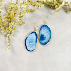 Discover the beauty of nature with our exquisite Natural Agate Slice Earrings. Each earring features a unique agate slice, plated with luxurious gold along the edges, adding a touch of elegance to the natural charm. 🌟 Key Features 🌟     Genuine Natural Agate Slices     Gold-Plated Edges     Matching Slices     One-of-a-Kind Earrings Our earrings are crafted from matching agate slices, carefully selected to complement each other. Since these slices are created from natural stone, they exhibit individual character, making each earring unique in its own way. They are 'sister' earrings, not identical twins, celebrating the beauty of nature's variations. With our Natural Agate Slice Earrings, you'll receive this exact pair, allowing you to adorn yourself with the essence of nature. Embrace th Blue Agate Earrings As A Gift, Handmade Blue Agate Earrings, Sister Earrings, Agate Slices, Agate Earrings, Agate Slice, Blue Agate, Unique Earrings, Timeless Beauty