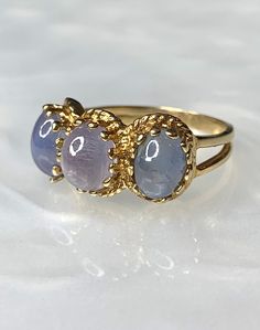 Star Sapphire Ring, Star Sapphire Ring for Women, Galaxy Ring, Celestial Ring, Vintage Star Sapphire Ring, Purple Star Sapphire, OOAK Ring A phenomenal vintage three stone ring featuring 3 purplish blue natural star sapphires with an approximate total weight of 6 carats, set beautifully and securely with multiple prongs in a split shank solid 14k yellow gold ring. The colors have been uniquely coordinated to create a blended Ombre effect, reminiscent of the early evening skies! * Ring size: US 5 Celestial Style Cabochon Yellow Gold Rings, Celestial Yellow Gold Cabochon Rings, Star-shaped Gemstone Rings For Formal Occasions, Celestial Multi-stone Round Rings, Yellow Gold Star-shaped Gemstone Ring, Celestial Oval Multi-stone Ring, Blended Ombre, Star Sapphire Jewelry, Dainty Earrings Studs