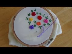 a close up of a cake on a table with flowers in the middle and thread