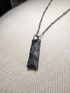 Show your appreciation for that special someone in your life by getting them this beautiful piece of handcrafted art for their special occasion. Each piece is designed, forged, and shaped by a local artist in the forests of Washington. The pendant is made of high-quality steel and is hand-shaped and polished to achieve its one-of-a-kind look that is sure to catch people's attention. One option (gray), keeps the pendant in its more natural unpolished, and rugged condition, with the tool marks and Hand Forged Stainless Steel Jewelry As Gift, Hand Forged Stainless Steel Jewelry For Gifts, Engraved Gunmetal Necklace For Gift, Hand Forged Square Pendant Jewelry Gift, Hand Forged Rectangular Pendant Jewelry As Gift, Hand Forged Rectangular Pendant Necklace As Gift, Hand Forged Rectangular Pendant Jewelry For Gift, Square Pendant Hand Forged Jewelry As A Gift, Gunmetal Sterling Silver Necklace For Gift