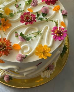 a cake decorated with flowers and icing on a gold plate