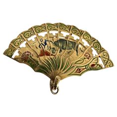 a decorative fan with animals on it hanging from a hook in front of a white background