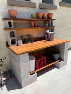 an outdoor kitchen made out of cinder blocks with pots and containers on the counter top