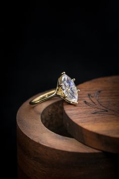 a diamond ring sitting on top of a wooden box